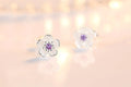 A pair of fine floral stud earrings in polished silver set with pink and purple zirconia stones