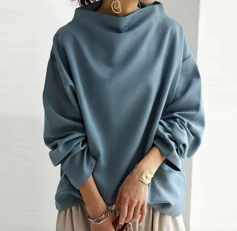 A woman wearing a soft funnel neck jumper styled with jeans for a relaxed elegant look.