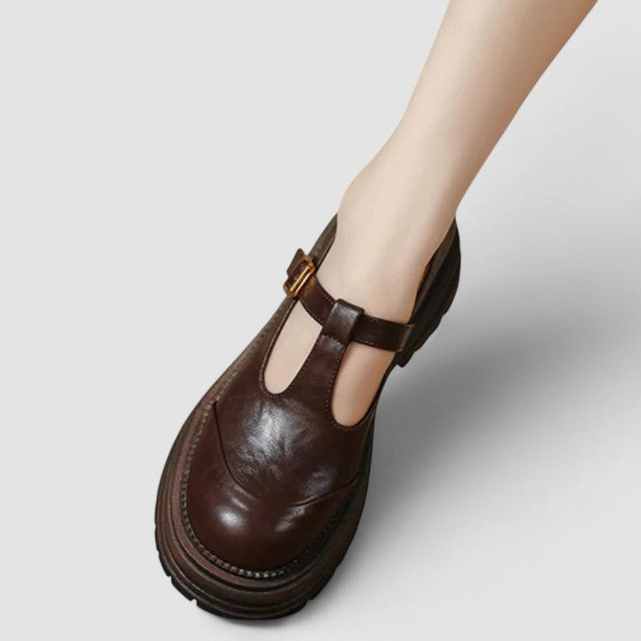 A woman wearing brown T-strap Mary Jane shoes, comfortable on a day around town.