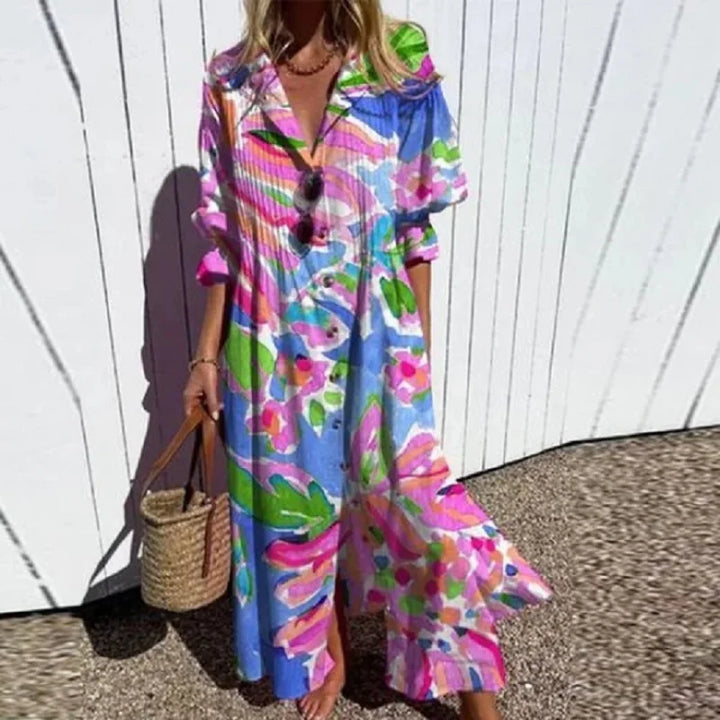 Woman wearing the Zara™ leaf print maxi dress with a button front, walking along the coast in a light breeze.