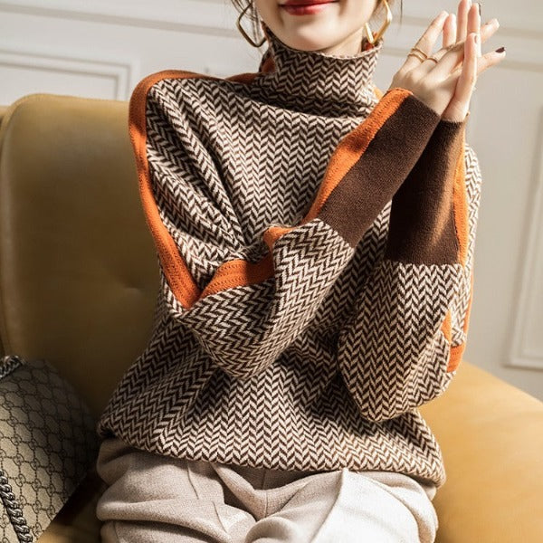 A woman wearing a brown and beige chevron high-collar jumper with bright green side stripes.