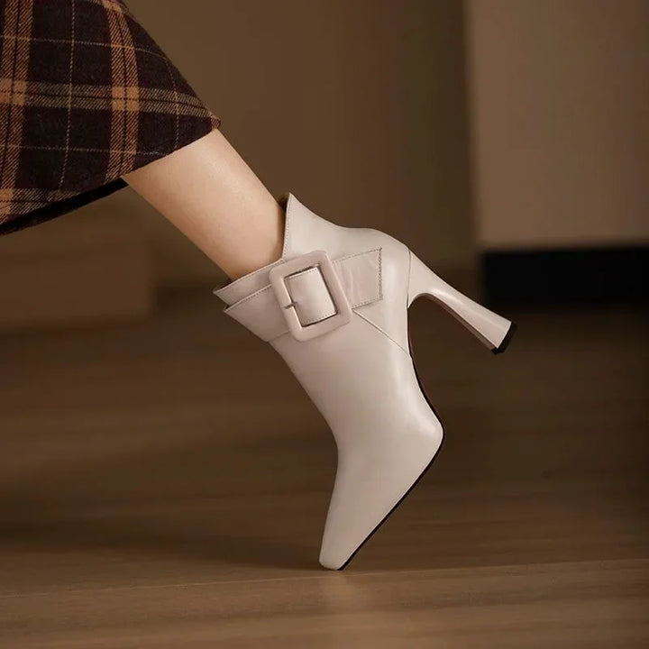 Sleek heeled ankle boots in beige and black with a side zip and structured silhouette