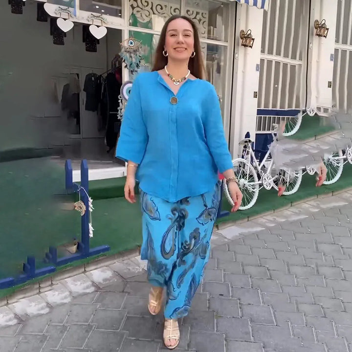 A woman wearing a bright blue blouse with matching patterned wide-leg trousers