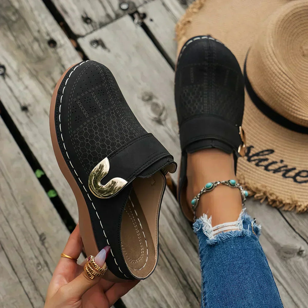 Black closed-toe clogs with decorative buckle detail