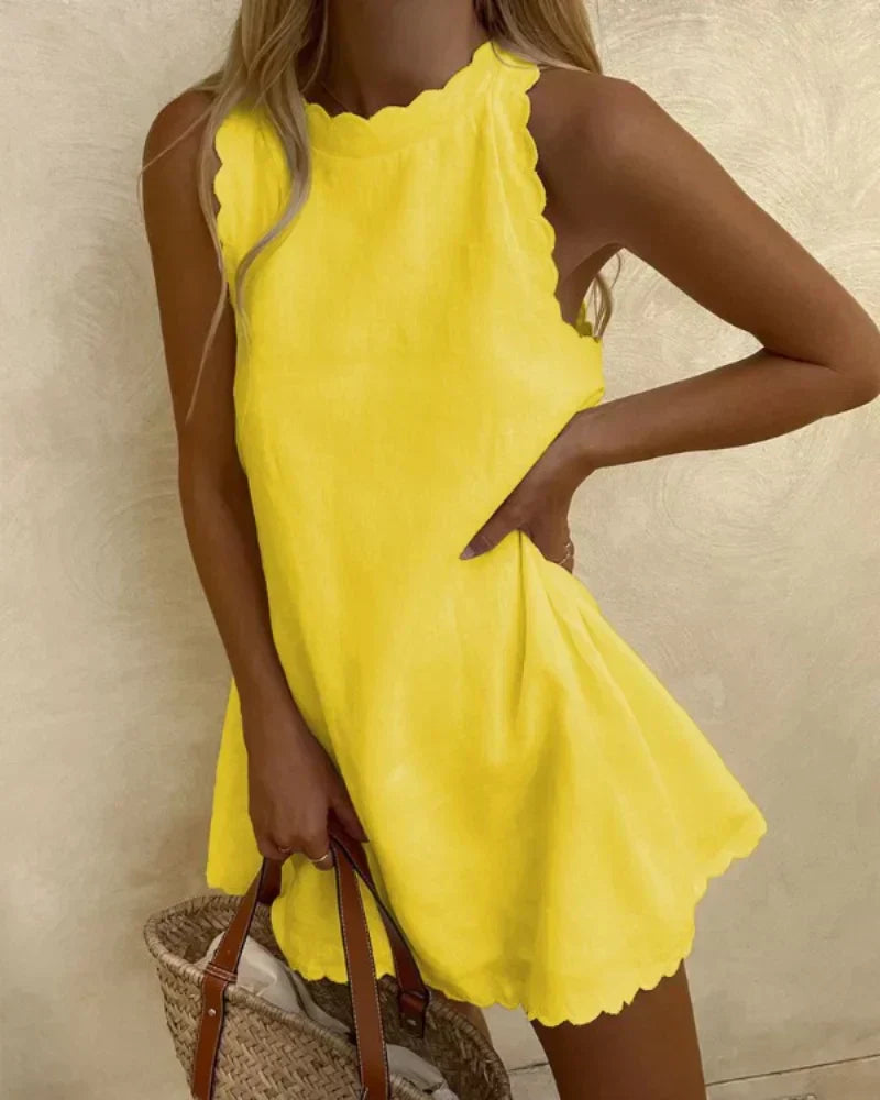 Woman wearing the Sophie ruffle-neck dress in yellow, twirling on a sunny street.