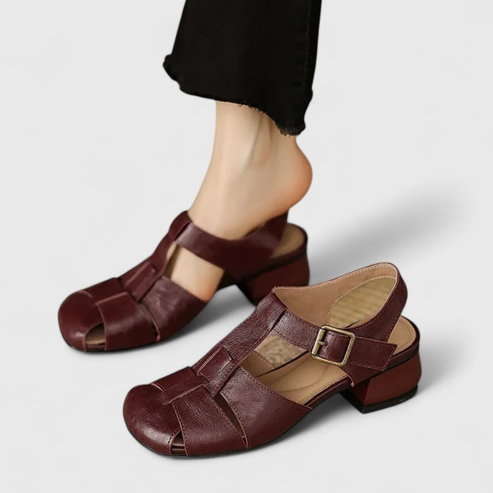 A woman wearing black chic evening sandals with a cushioned footbed at a special occasion.