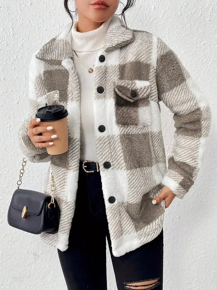 A woman wearing a soft checked jacket over casual clothes on a cool autumn morning.