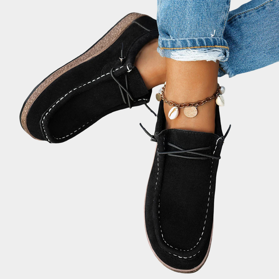 A woman wearing black boho-print lace-up comfort shoes while running errands.