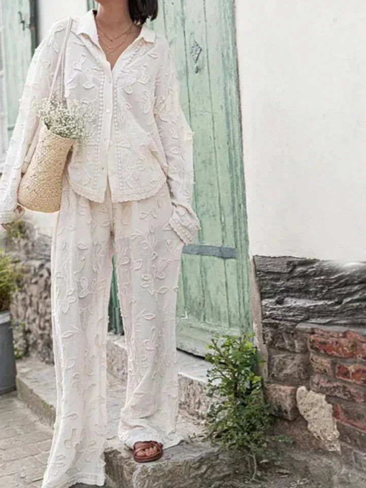 A woman wearing an embroidered relaxed two-piece set with wide trousers