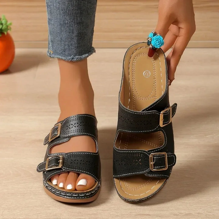 A woman walking with ease in wide-fit adjustable orthopaedic sandals with cushioned soles.