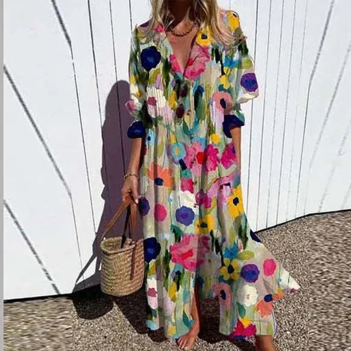 Woman wearing the Zara™ leaf print maxi dress with a button front, walking along the coast in a light breeze.