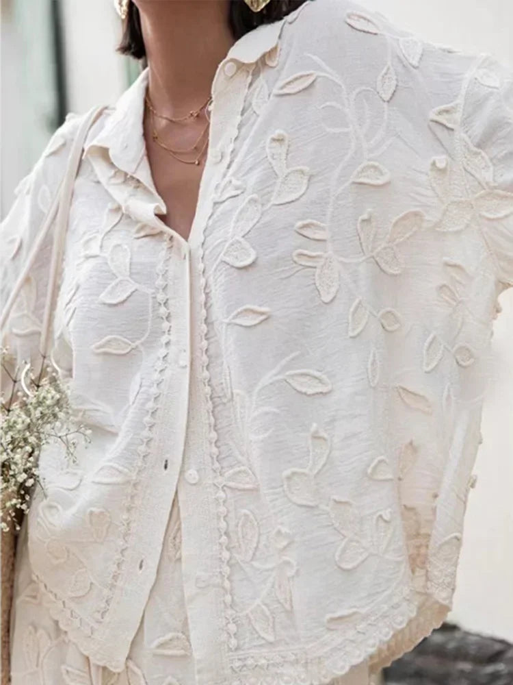 A woman wearing an embroidered relaxed two-piece set with wide trousers