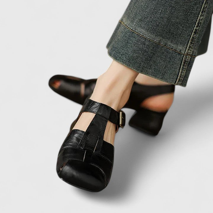 A woman wearing black chic evening sandals with a cushioned footbed at a special occasion.