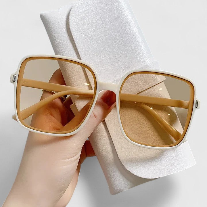 A woman wearing vintage-inspired oversized sunglasses in the sun, elegant and relaxed.