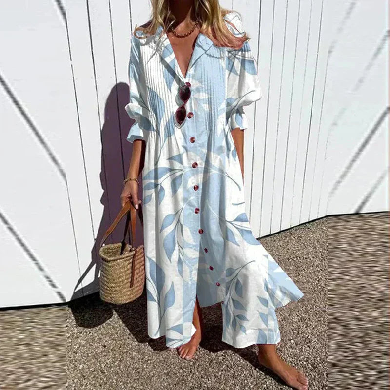 Woman wearing the Zara™ leaf print maxi dress with a button front, walking along the coast in a light breeze.