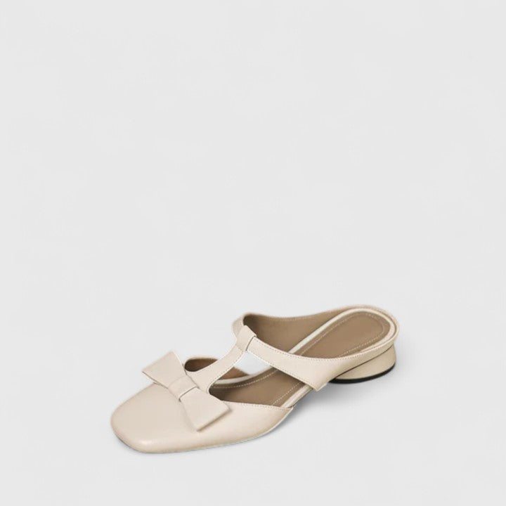 A woman wearing soft pink comfort sandals with a broad, cushioned footbed on a sunny day.