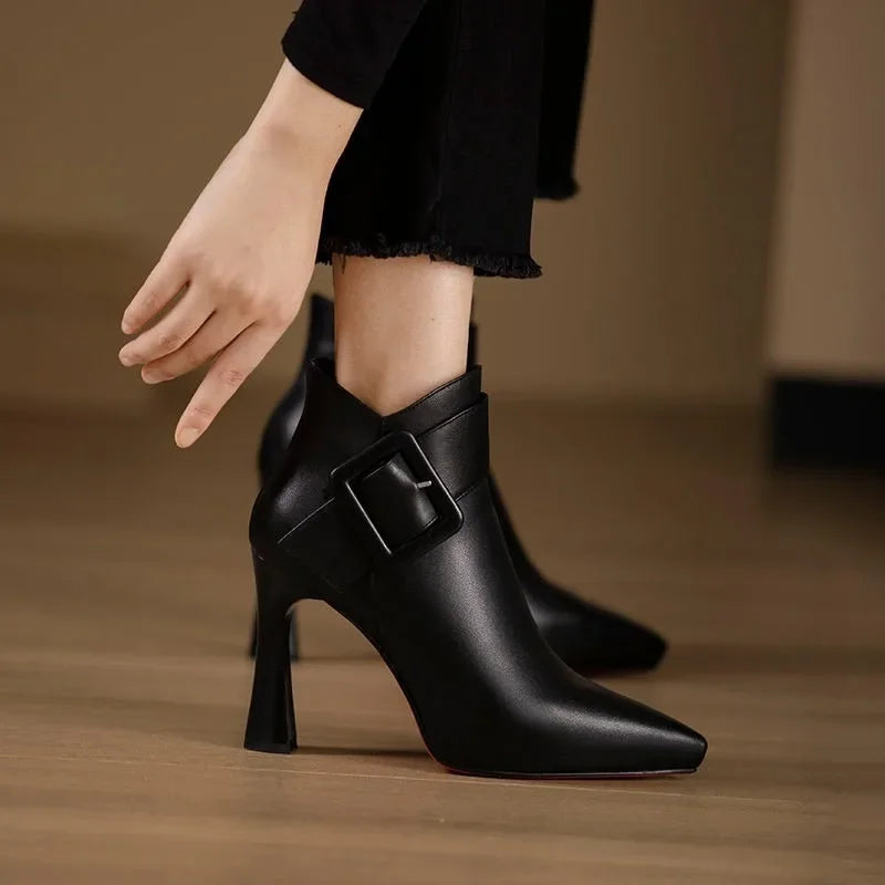 Sleek heeled ankle boots in beige and black with a side zip and structured silhouette