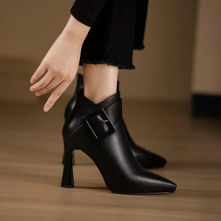 Sleek heeled ankle boots in beige and black with a side zip and structured silhouette