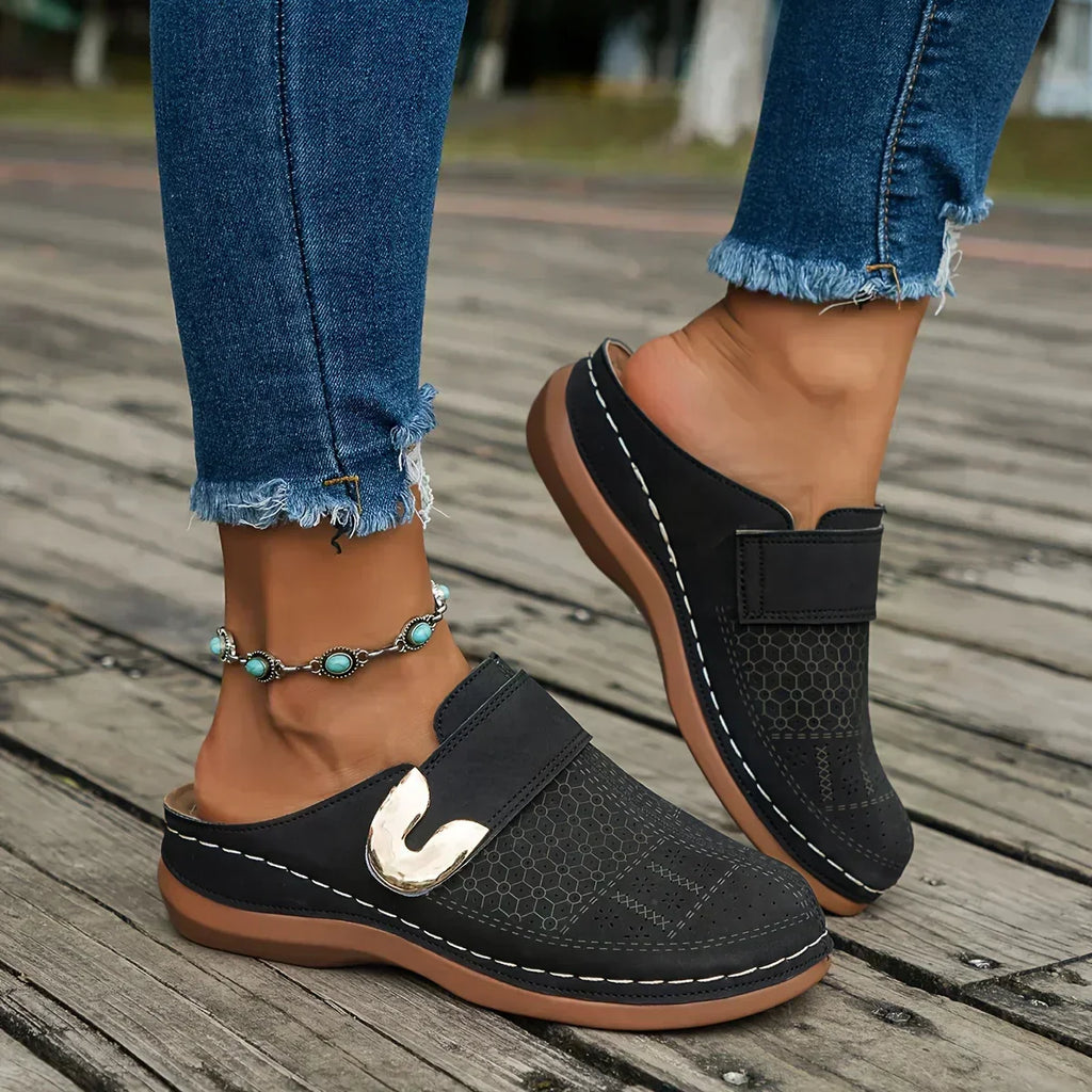 Black closed-toe clogs with decorative buckle detail