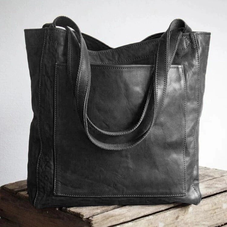 A woman holding a classic handbag with a rich finish by her side