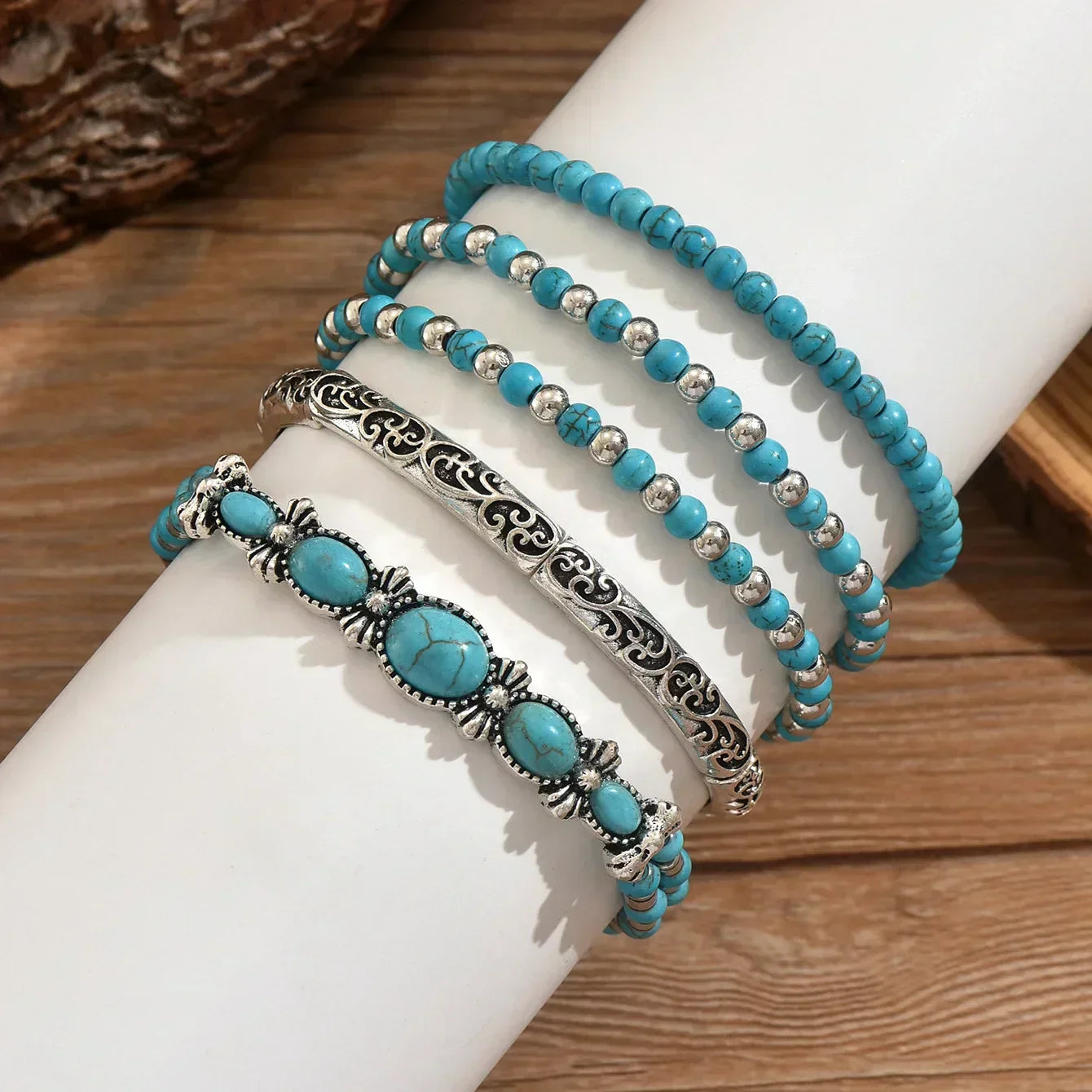 Set of turquoise and metallic boho-style stacking bracelets on a white background