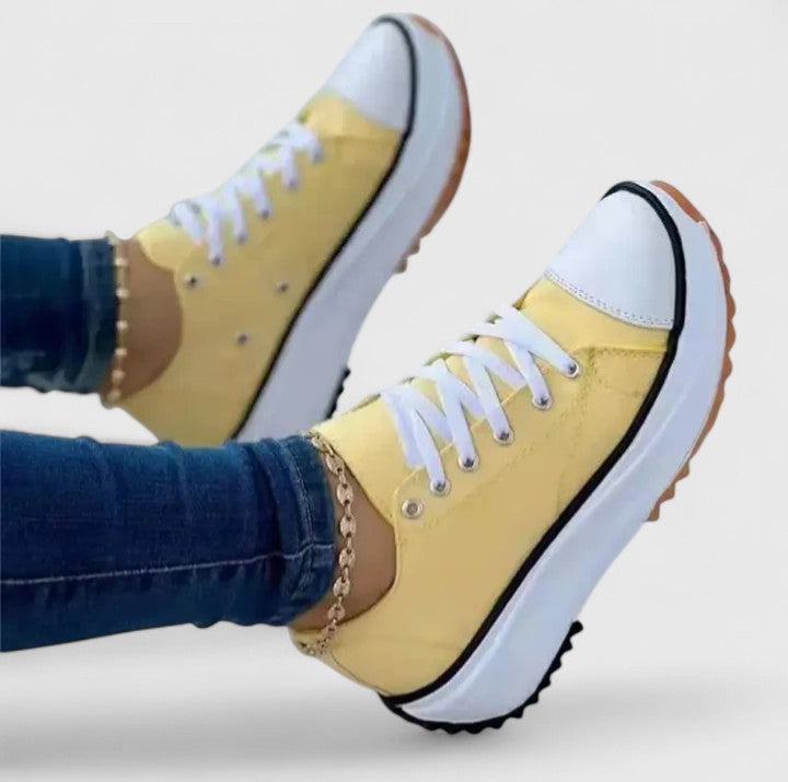 A woman in bold lace-up platform comfort trainers styled with jeans.