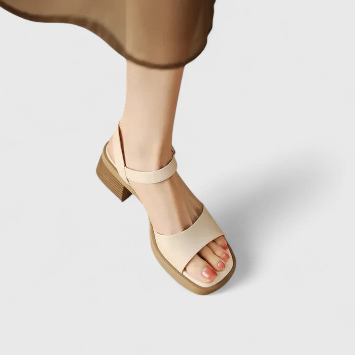 A woman in brown block heel sandals with an ankle strap, dressed for the day.