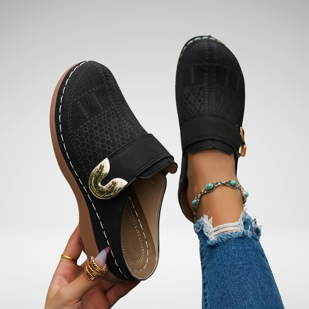 Black closed-toe clogs with decorative buckle detail