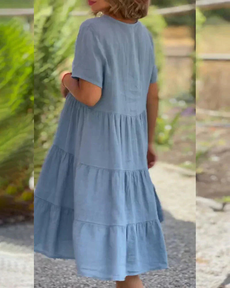 Woman wearing the Veronica™ V-neck summer dress with a soft layered skirt, strolling on a sunny afternoon.