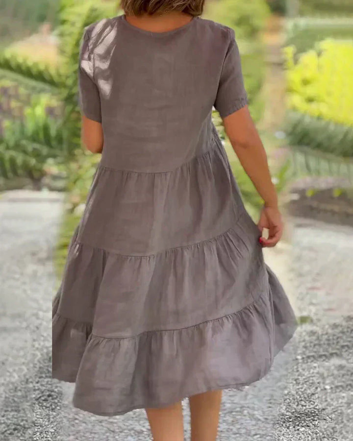 Woman wearing the Veronica™ V-neck summer dress with a soft layered skirt, strolling on a sunny afternoon.