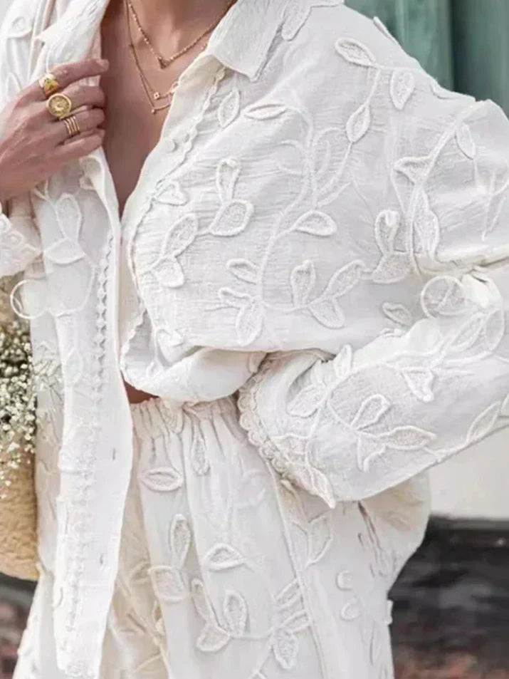 A woman wearing an embroidered relaxed two-piece set with wide trousers