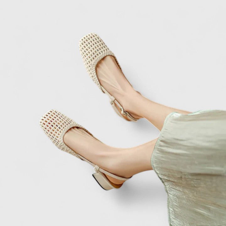 A woman wearing soft pink comfort sandals with a broad, cushioned footbed on a sunny day.
