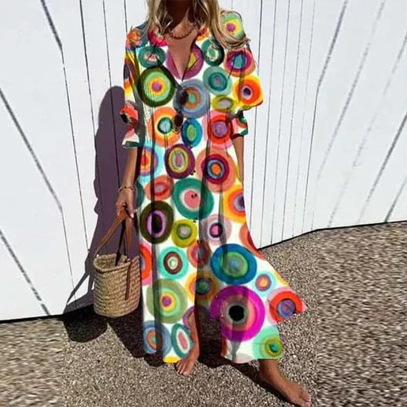 Woman wearing the Zara™ leaf print maxi dress with a button front, walking along the coast in a light breeze.