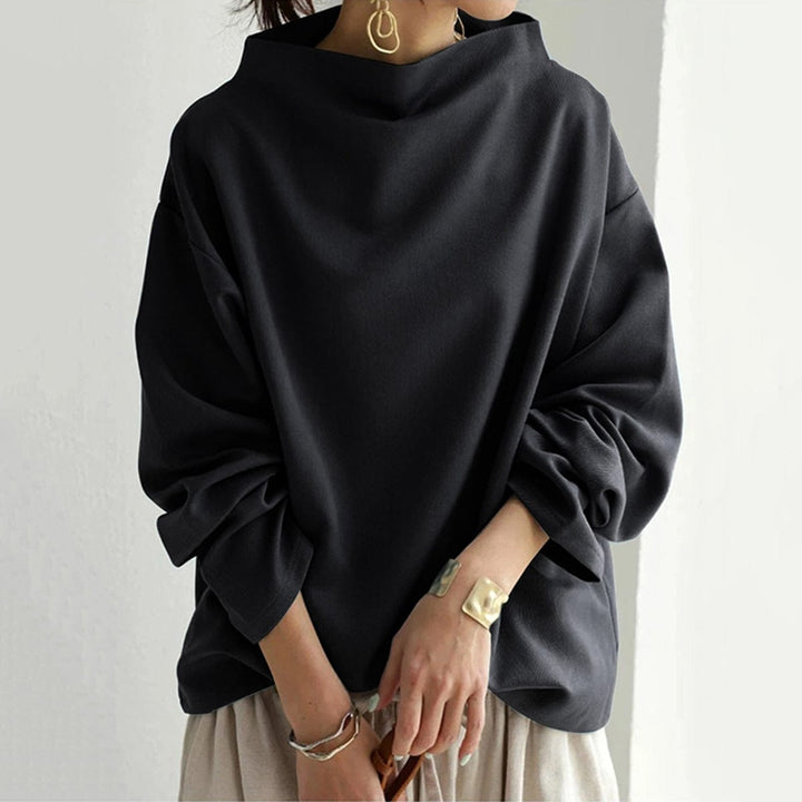 A woman wearing a soft funnel neck jumper styled with jeans for a relaxed elegant look.
