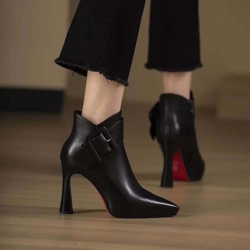 Sleek heeled ankle boots in beige and black with a side zip and structured silhouette