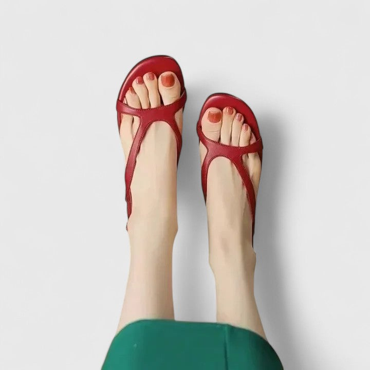 Cream toe-post sandals with a slingback buckle and a block heel set with a pearl.