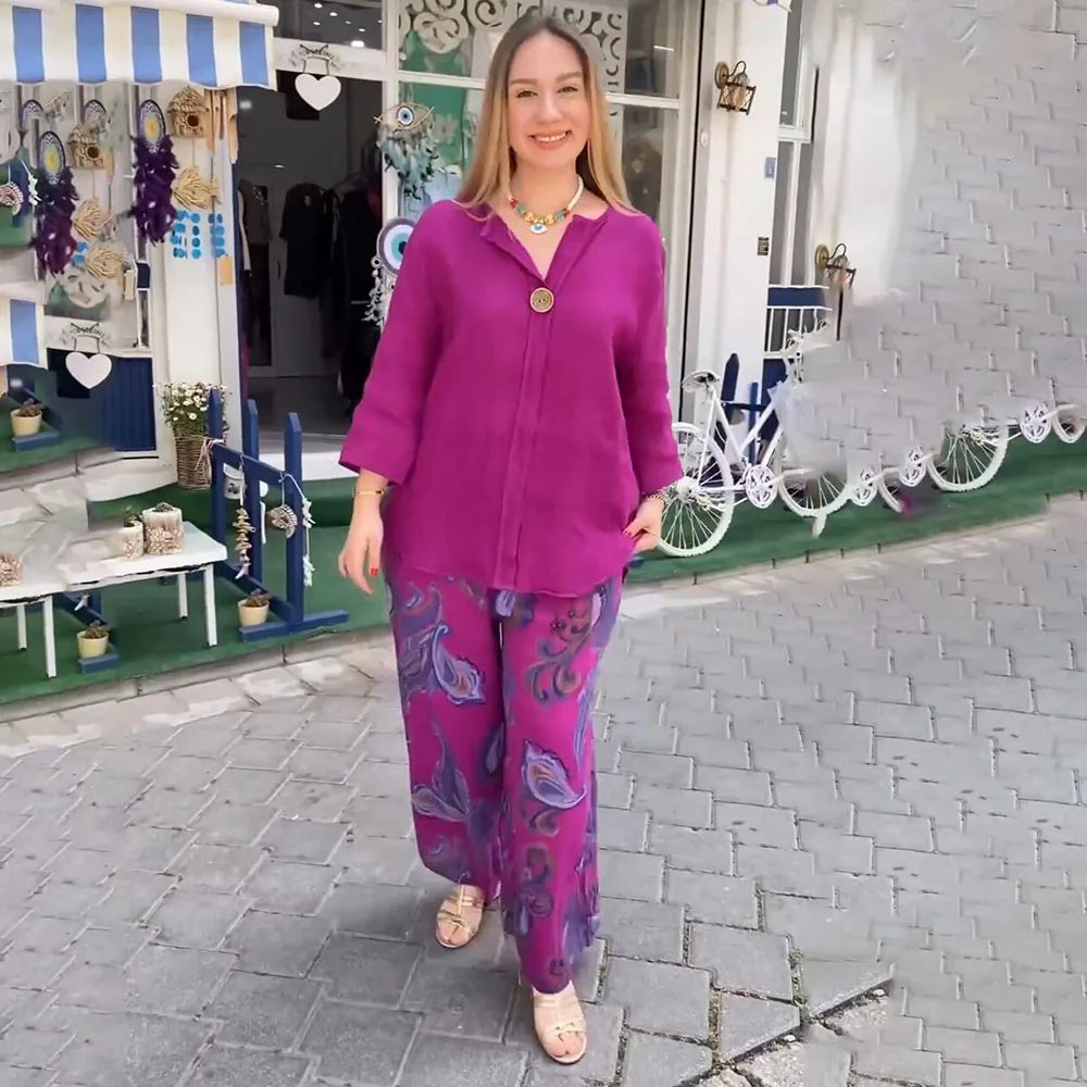 A woman wearing a bright blue blouse with matching patterned wide-leg trousers