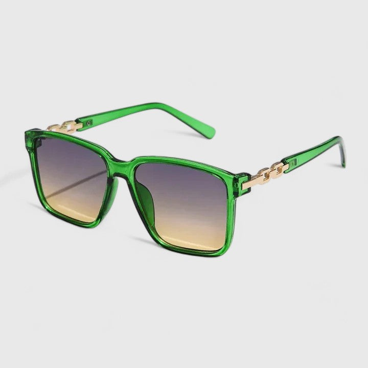 A woman by the pool wearing bold square sunglasses with chain-detail temples, confident in the sun.