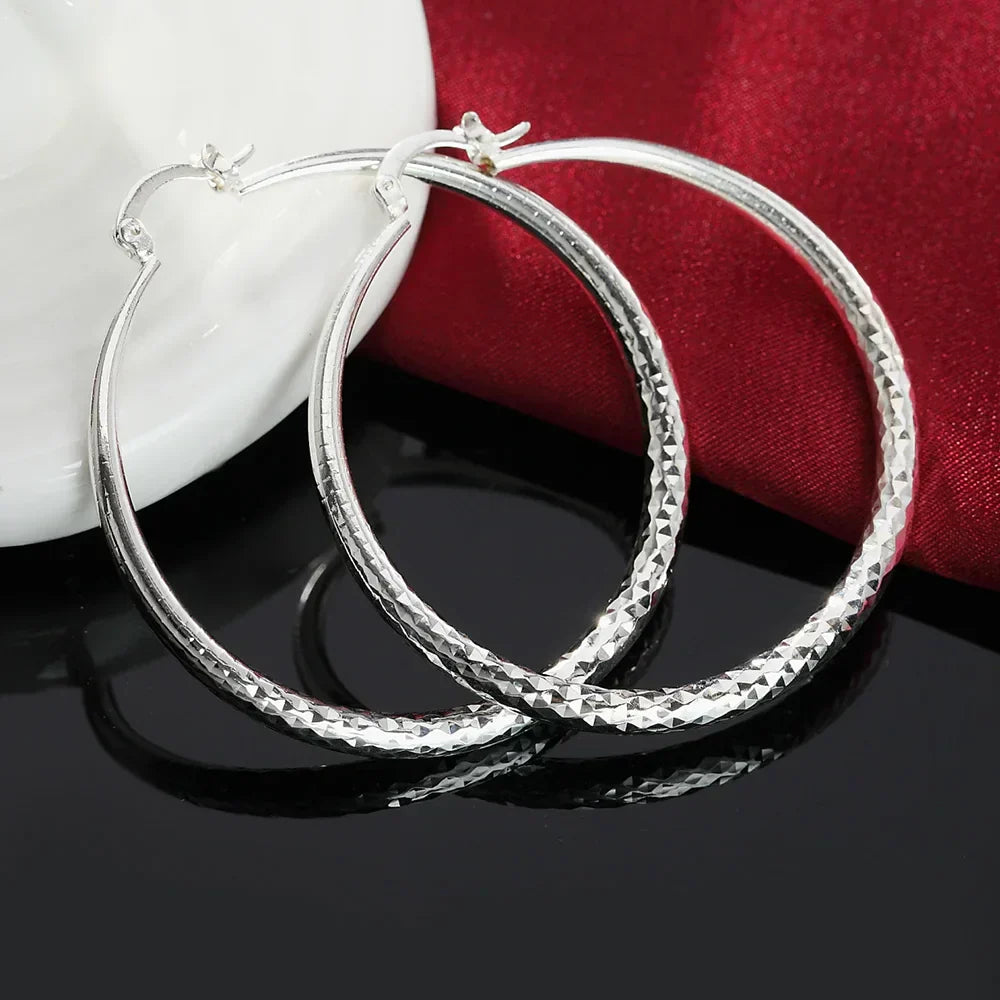 A pair of polished 925 sterling silver circular hoop earrings with a high-shine finish