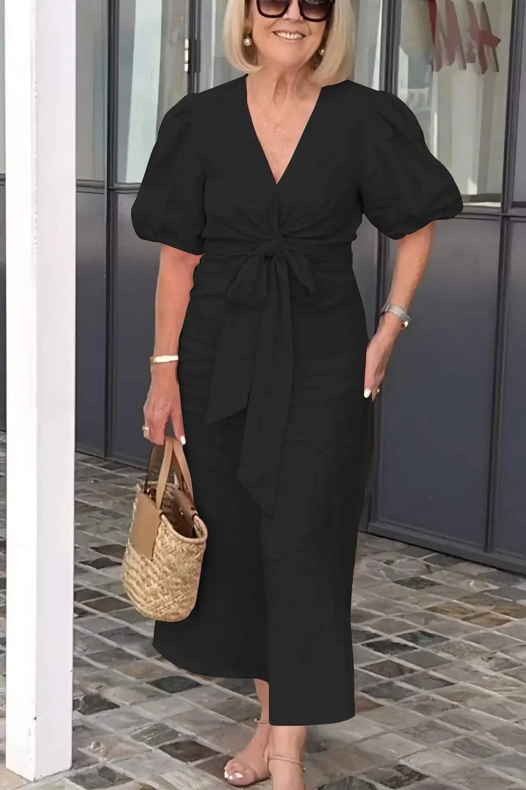 Woman wearing the Bridget bow-front midi dress with puff sleeves at a garden party.