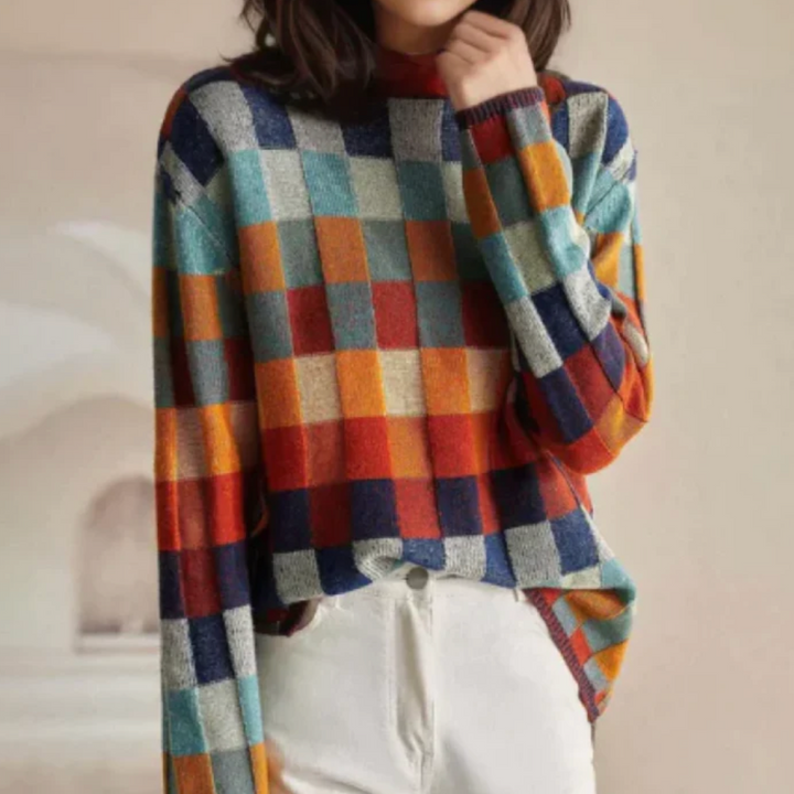 A woman wearing a colourful retro check jumper, relaxed and cosy on a cool autumn morning.