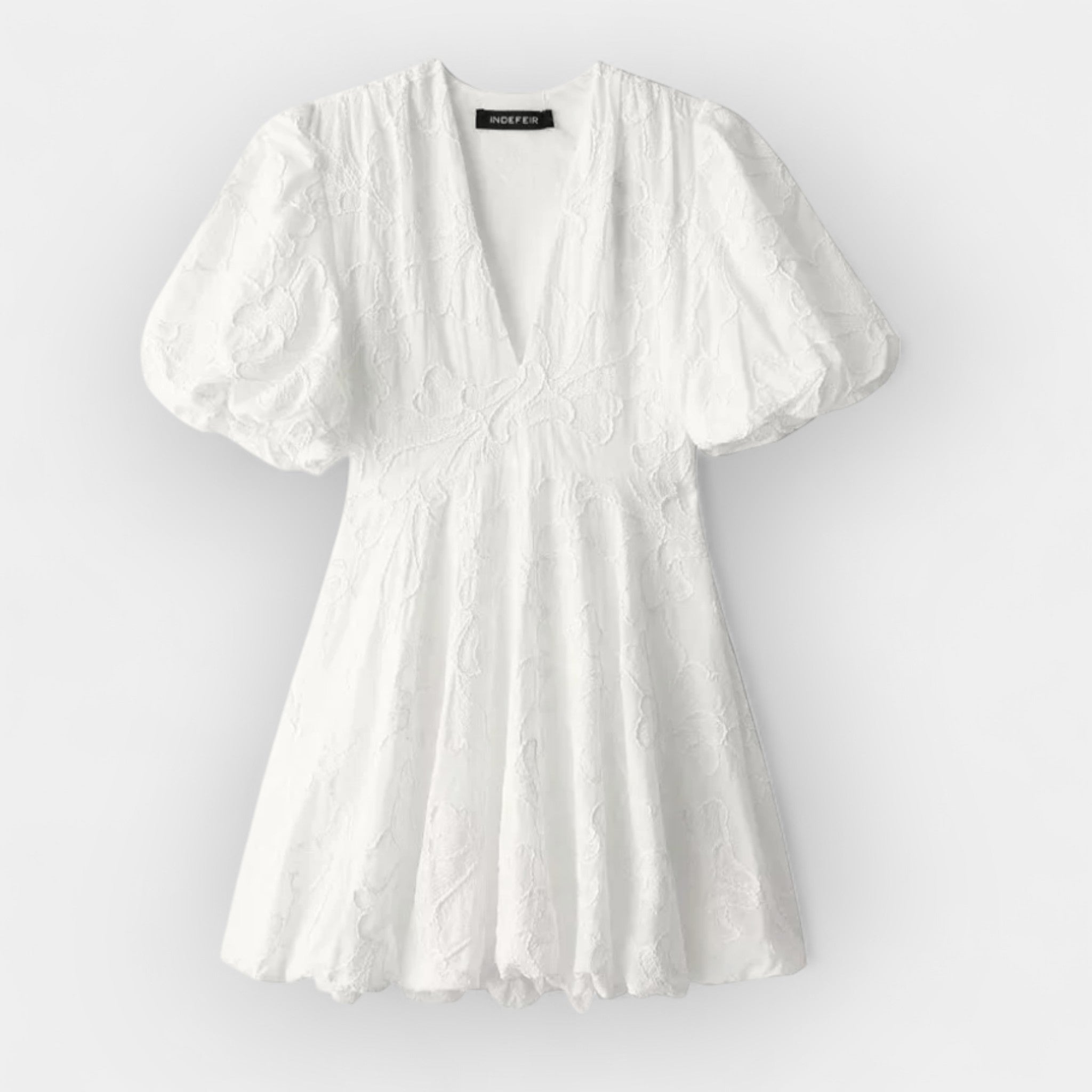 Flowing white summer dress with a soft romantic silhouette and gentle movement
