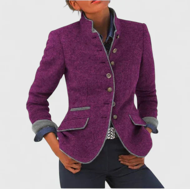 A woman wearing a structured tailored jacket with a defined waist over jeans, looking confident.