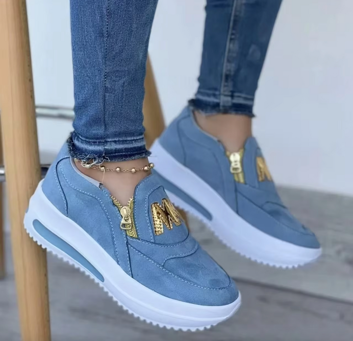 A woman wearing cushioned side-zip trainers with a relaxed everyday outfit