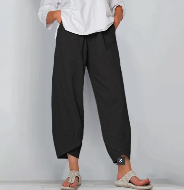A woman wearing lightweight plain trousers with an elastic waist and handy pockets.
