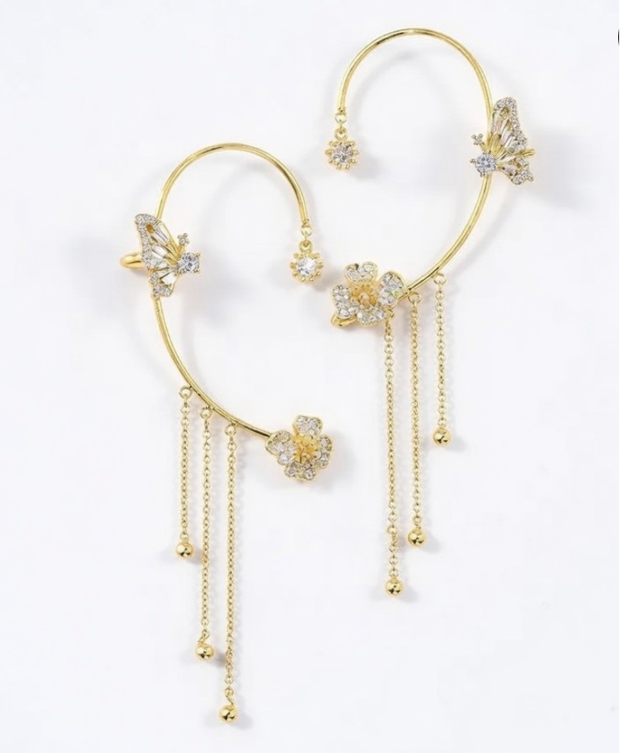 Gold celestial arc earring with a butterfly detail, framing the ear with sparkling luminosity