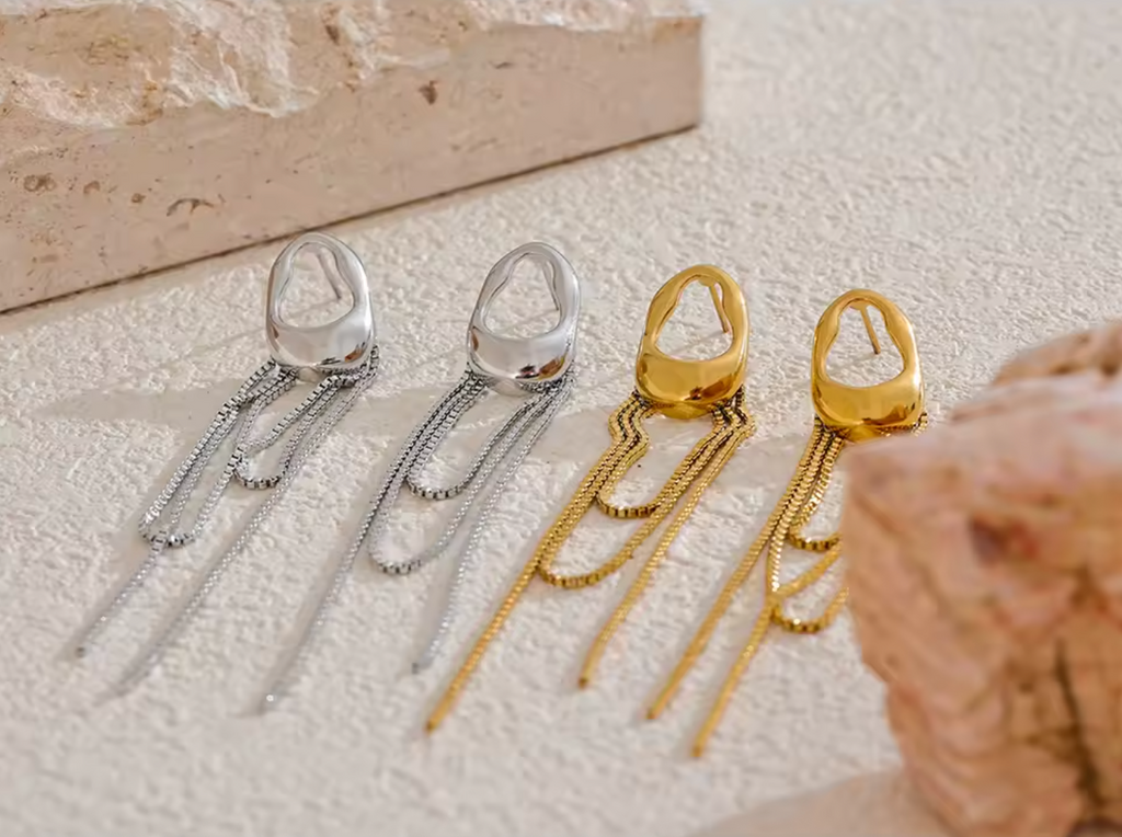 A pair of gold minimalist drop earrings with fine moving chain details