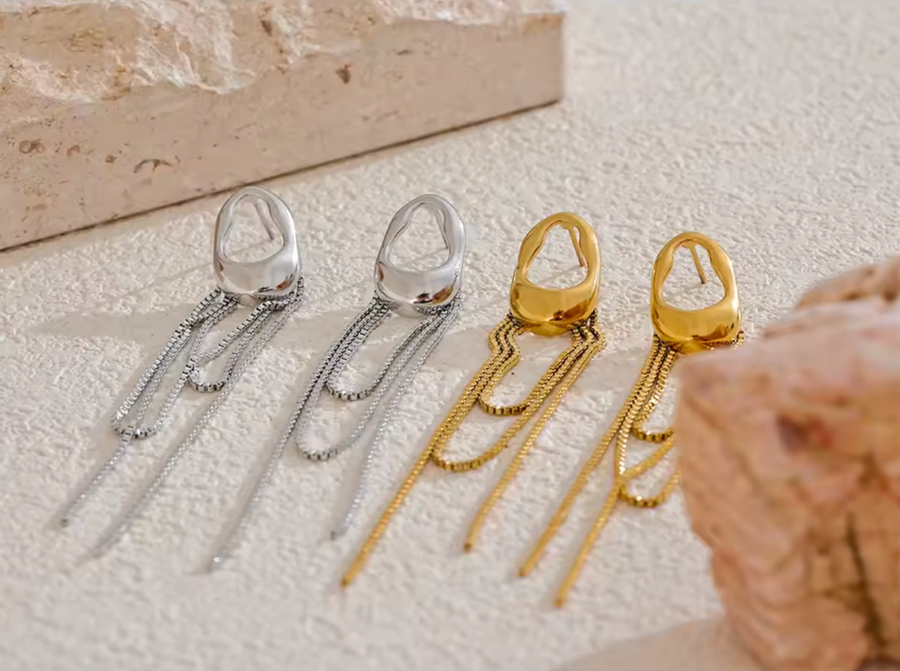 A pair of gold minimalist drop earrings with fine moving chain details