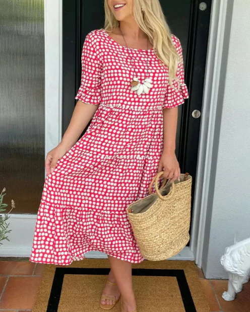 A woman wearing the Angela short sleeve midi dress with a flowing skirt on a warm day.