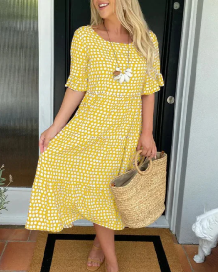 A woman wearing the Angela short sleeve midi dress with a flowing skirt on a warm day.